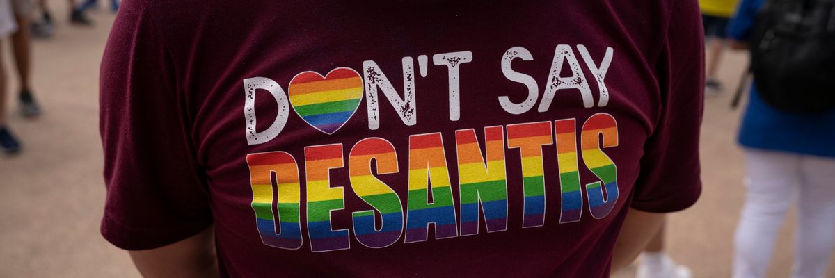 Man wears rainbow-colored "Don't Say DeSantis" t-shirt.