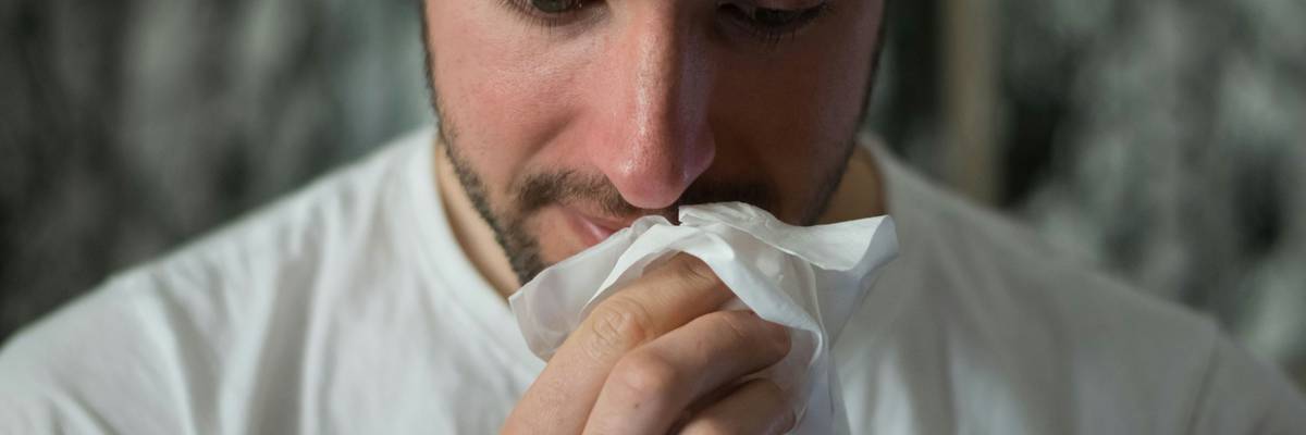 Man wiping his nose.