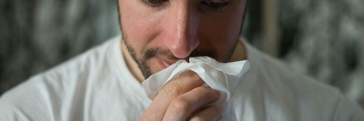 Man wiping his nose.