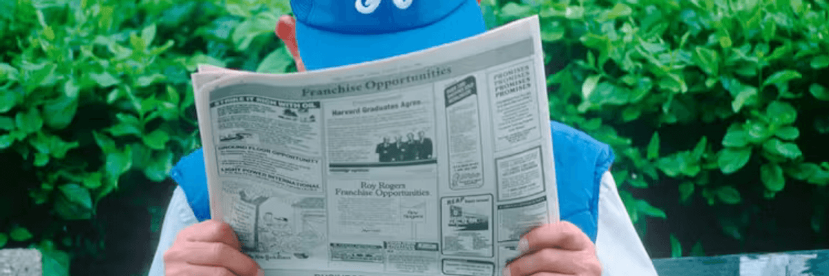 Man with hat reading newspaper