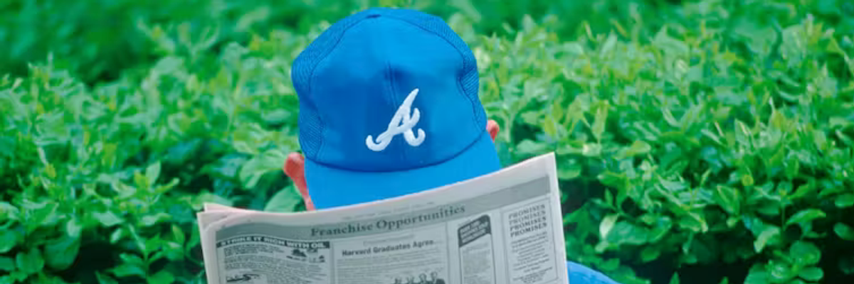 Man with hat reading newspaper
