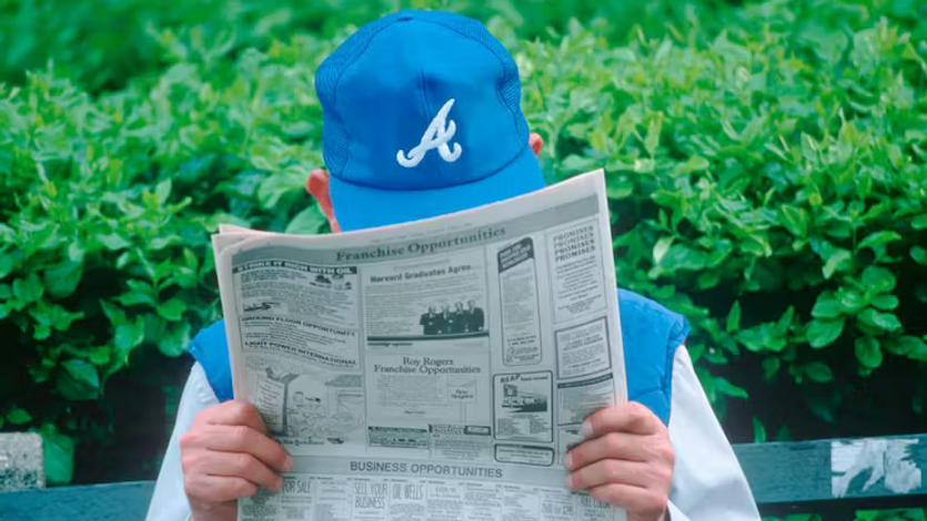 Man with hat reading newspaper