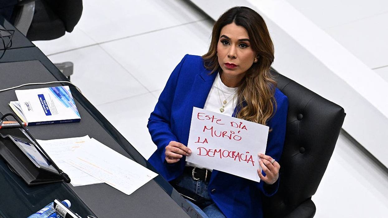 Marcela Villatoro, an opposition lawmaker in El Salvador, holds a sign that reads "Democracy Died Today"