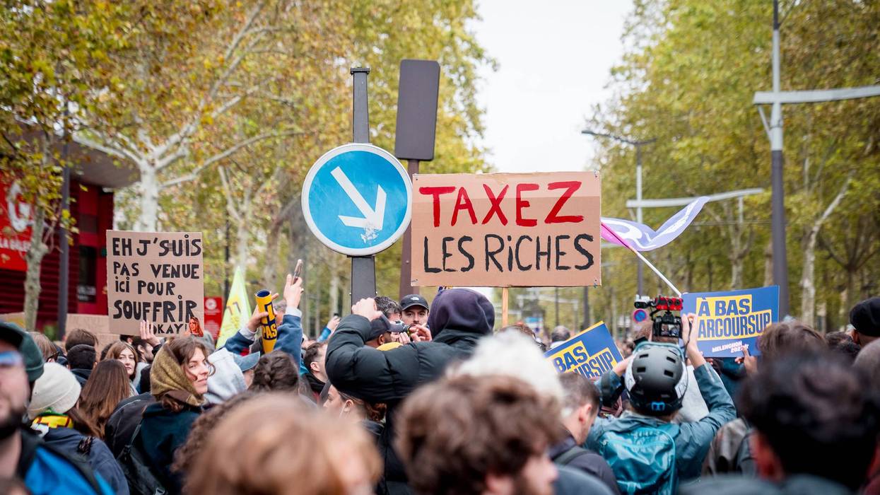March in Paris with sign saying Tax the rich in French.