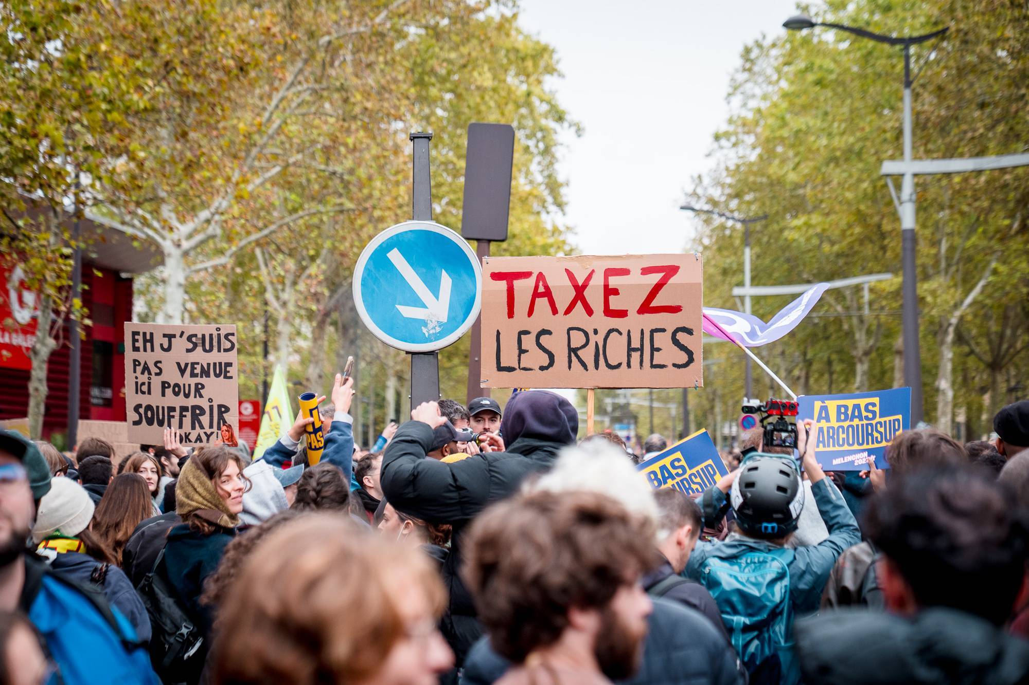 March in Paris with sign saying Tax the rich in French.