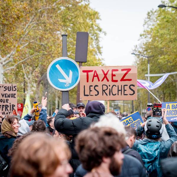 March in Paris with sign saying Tax the rich in French.