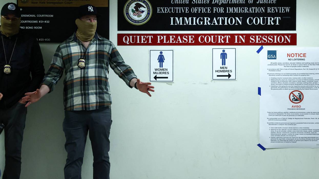 Masked federal agents stand in a hallway at the New York Federal Plaza Immigration Court