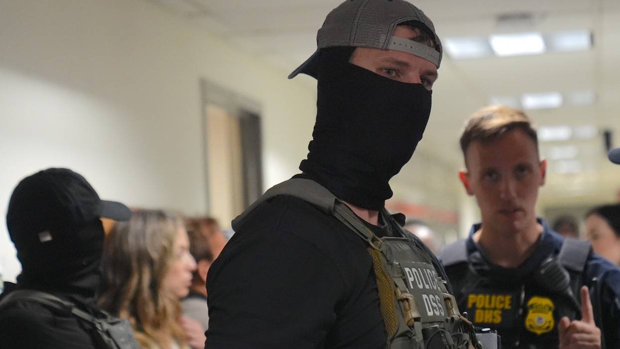 Masked federal agents wait outside the immigration court at the Jacob K. Javits building
