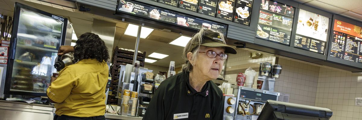 McDonald's worker taking an order at a counter.