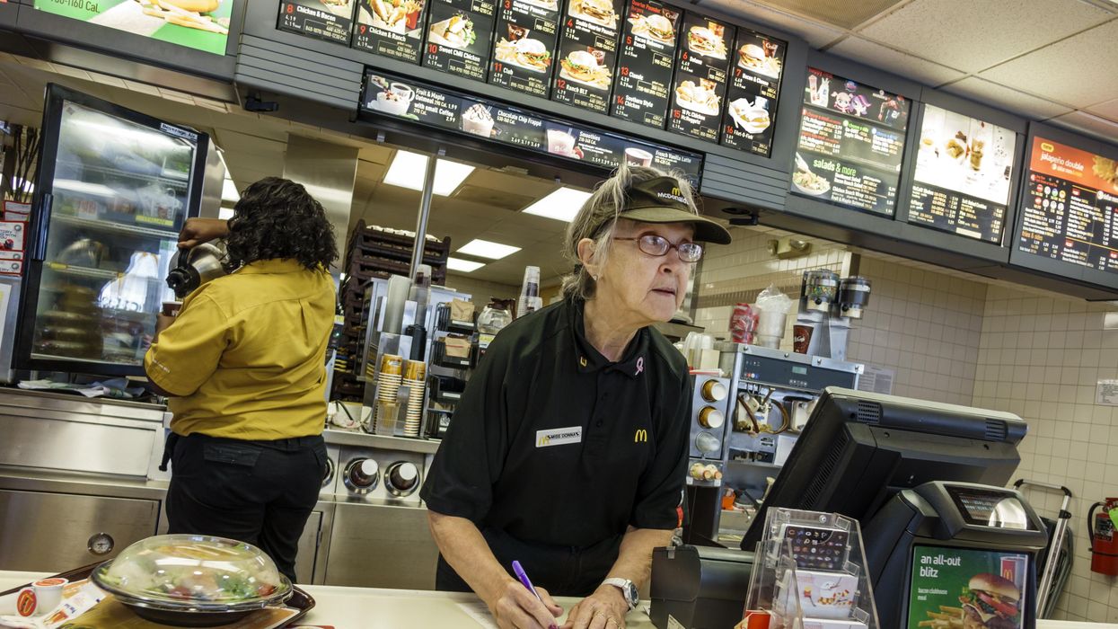 McDonald's worker taking an order at a counter.