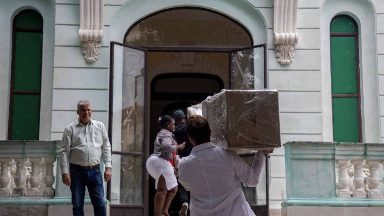 Medical worker in Cuba carries box of aid supplies.
