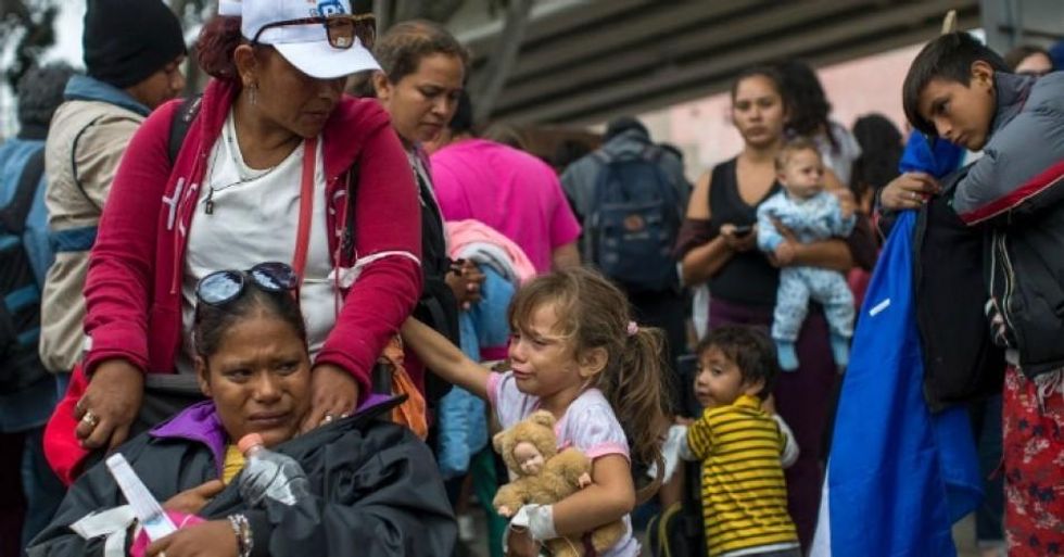 Members of a caravan of Central Americans who spent weeks traveling across Mexico walk from Mexico to the U.S. side of the border to ask authorities for asylum on April 29, 2018 in Tijuana, Baja California Norte, Mexico. (Photo: David McNew/Getty Images)