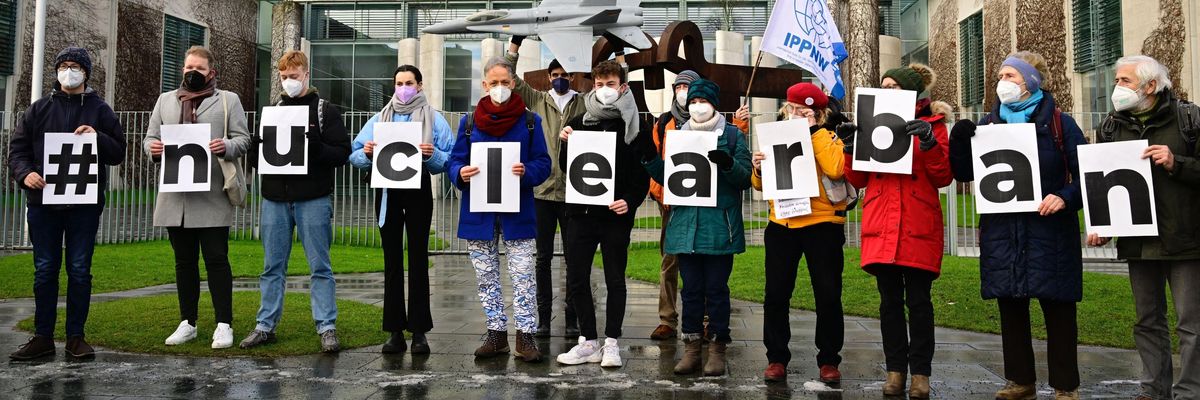 Members of International Physicians for the Prevention of Nuclear War and International Campaign to Abolish Nuclear Weapons hold signs reading “#nuclear ban.”