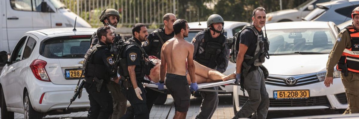 Members of Israeli security forces carry an injured person on a stretcher