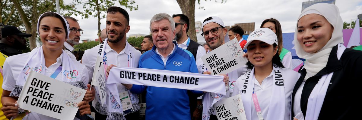 Members of the 2024 Refugee Olympic Team with IOC President Thomas Bach.