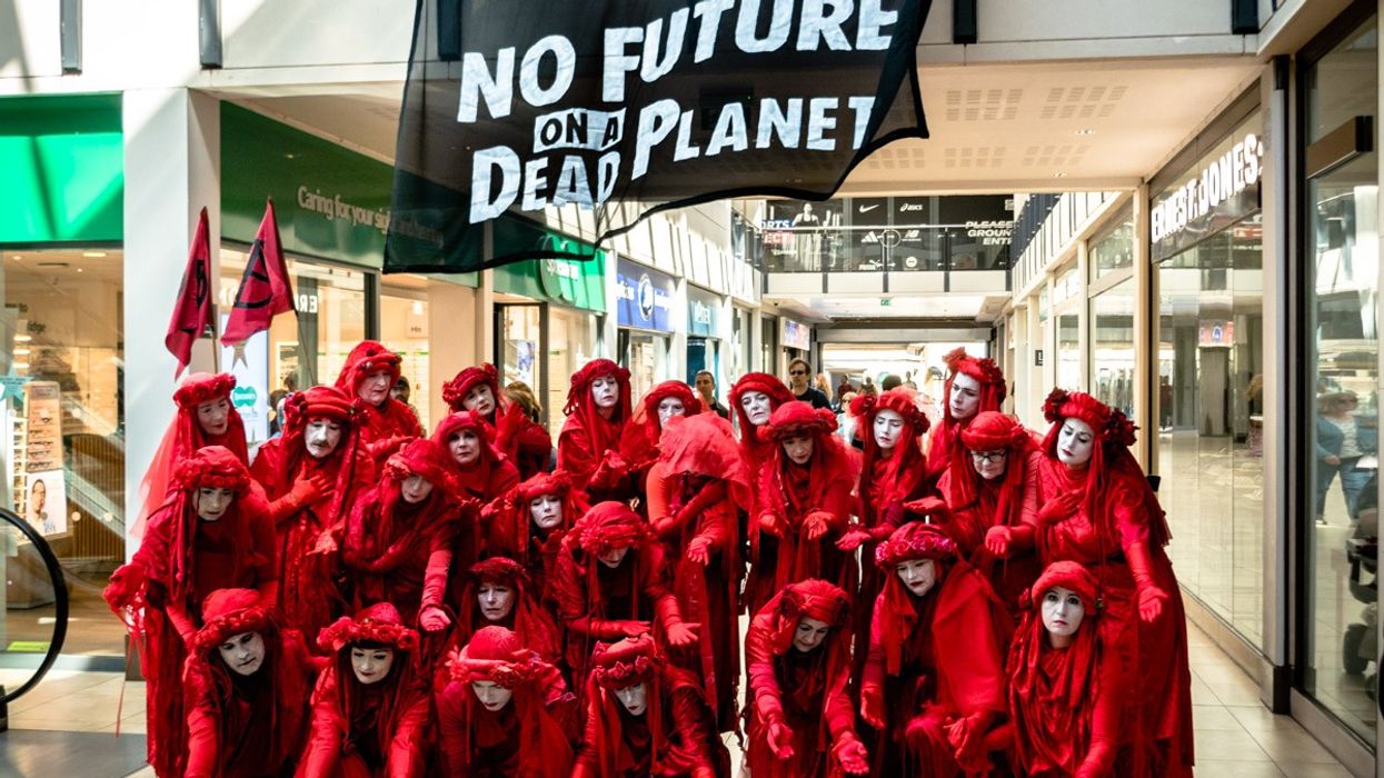 Members of the "Red Rebel Brigade" led a procession around Cambridge, England as part of a funeral for the Paris agreement's 1.5°C temperature target