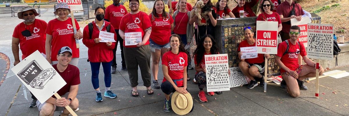 Members of the Seattle Education Association pose in front of one of the city's public school buildings while on strike on September 12, 2022.