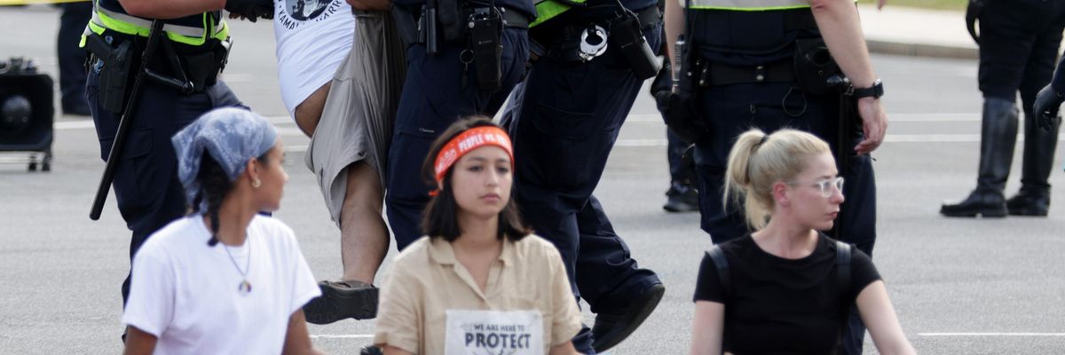 Members of the U.S. Capitol Police arrest a climate activist as he participates in civil disobedience during a protest on Capitol Hill October 15, 2021 in Washington, D.C.