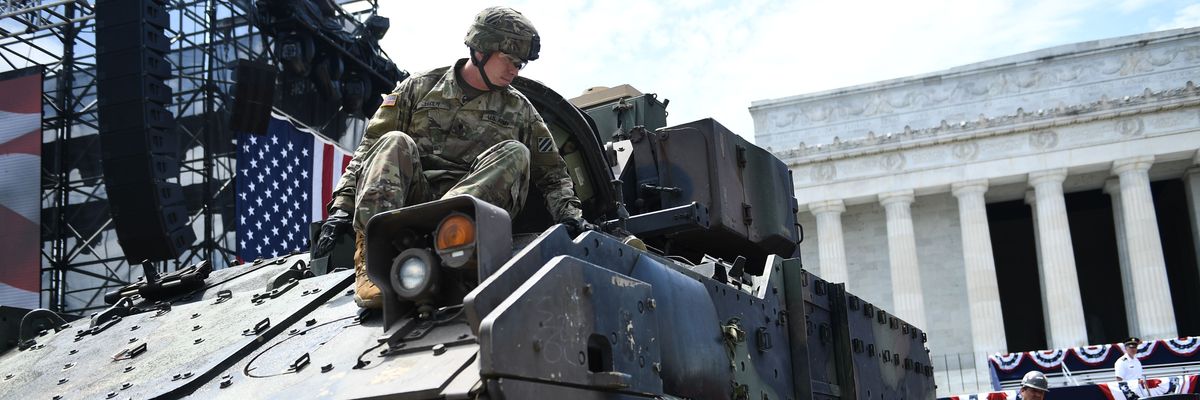 Members of the U.S. military are seen next to a Bradley Fighting Vehicle.