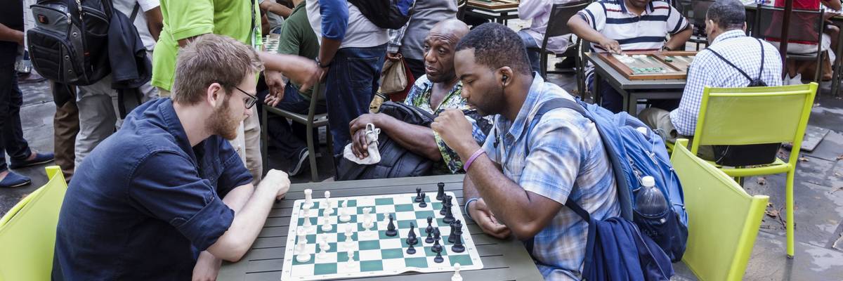 Men playing chess in a park.