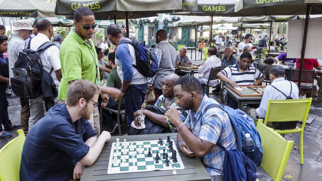 Men playing chess in a park.