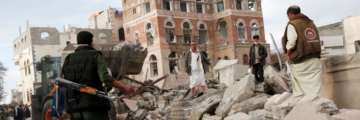 Men search rubble of building bombed by US in Sanaa, Yemen