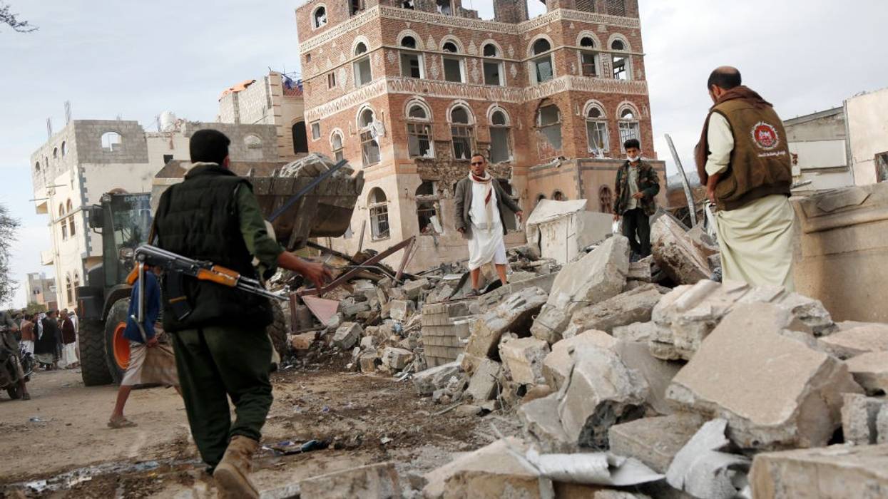 Men search rubble of building bombed by US in Sanaa, Yemen