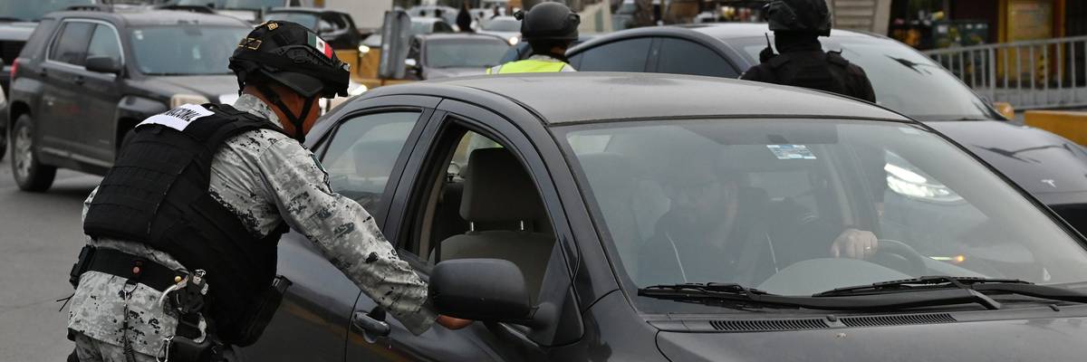 Mexican National Guard checking cars at U.S. border.