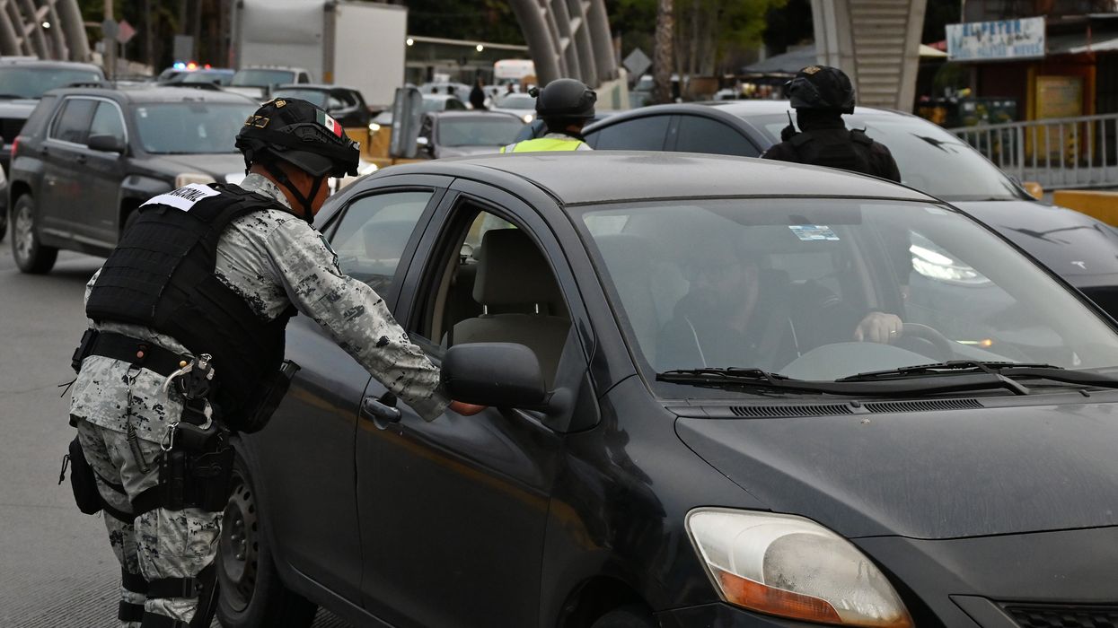 Mexican National Guard checking cars at U.S. border.