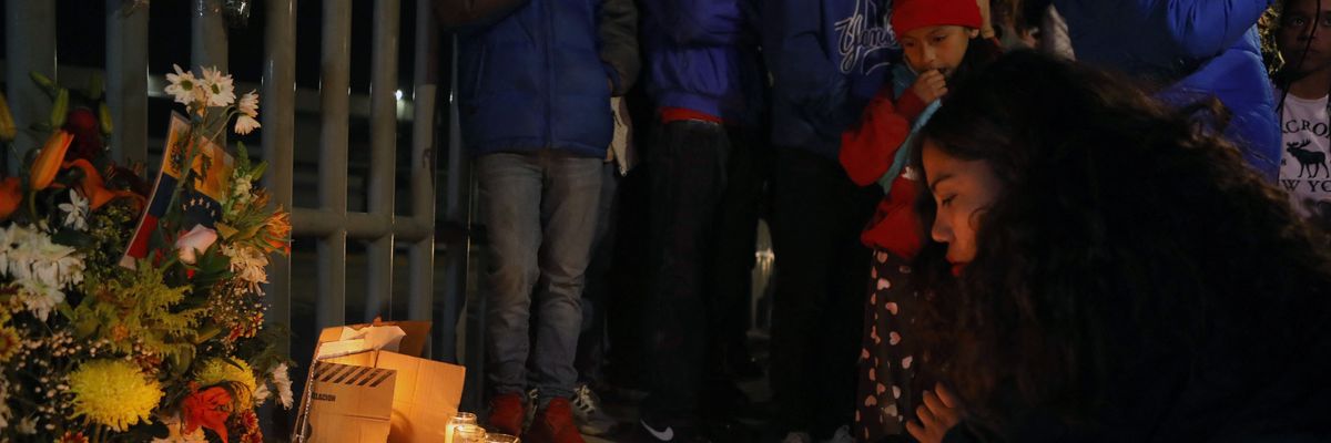 Migrants and activists light candles at a vigil