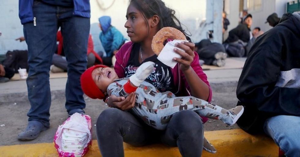 Migrants gather outside a temporary shelter set up for members of the 'migrant caravan' on November 24, 2018 in Tijuana, Mexico.  (Photo: Mario Tama/Getty Images)