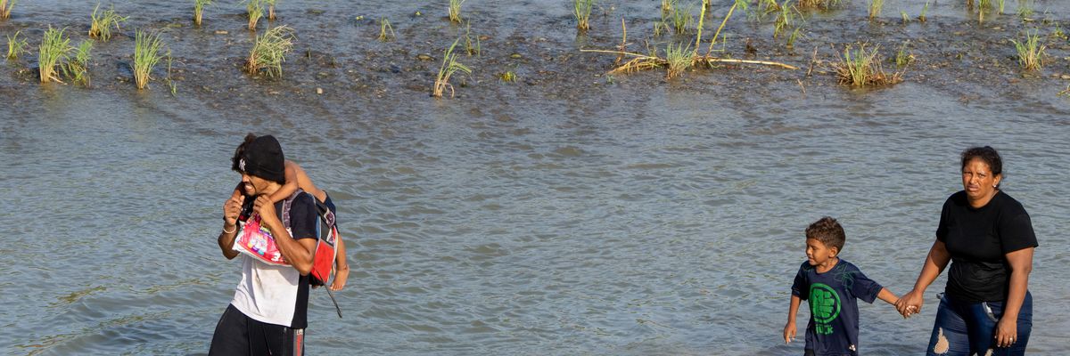 Migrants walk in the Rio Grande