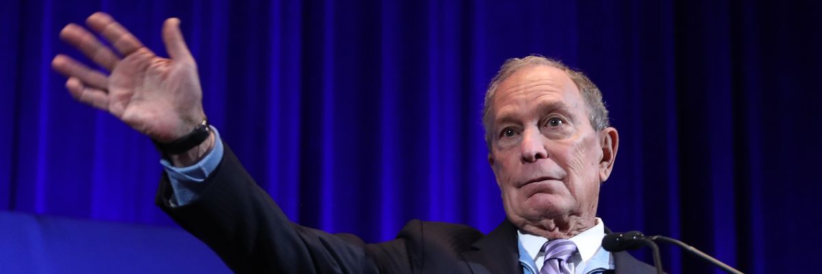 Mike Bloomberg gestures at the audience.