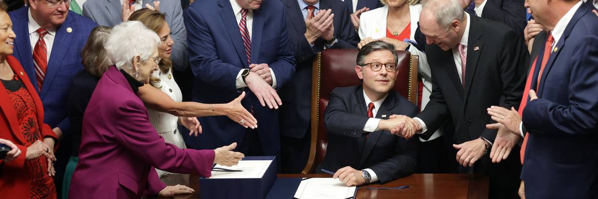 Mike Johnson shakes hands after signing OBBB.