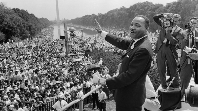 Mlk waves to a crowd on the national Mall.