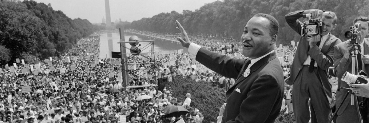 Mlk waves to a crowd on the national Mall.