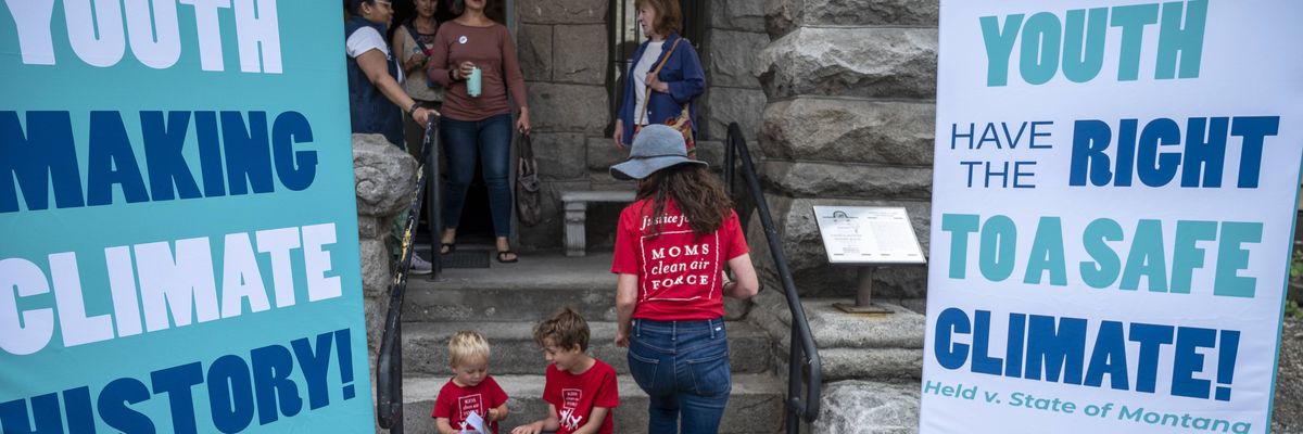 Montana choldren and a mother are seen near signs advocating youth climate justice