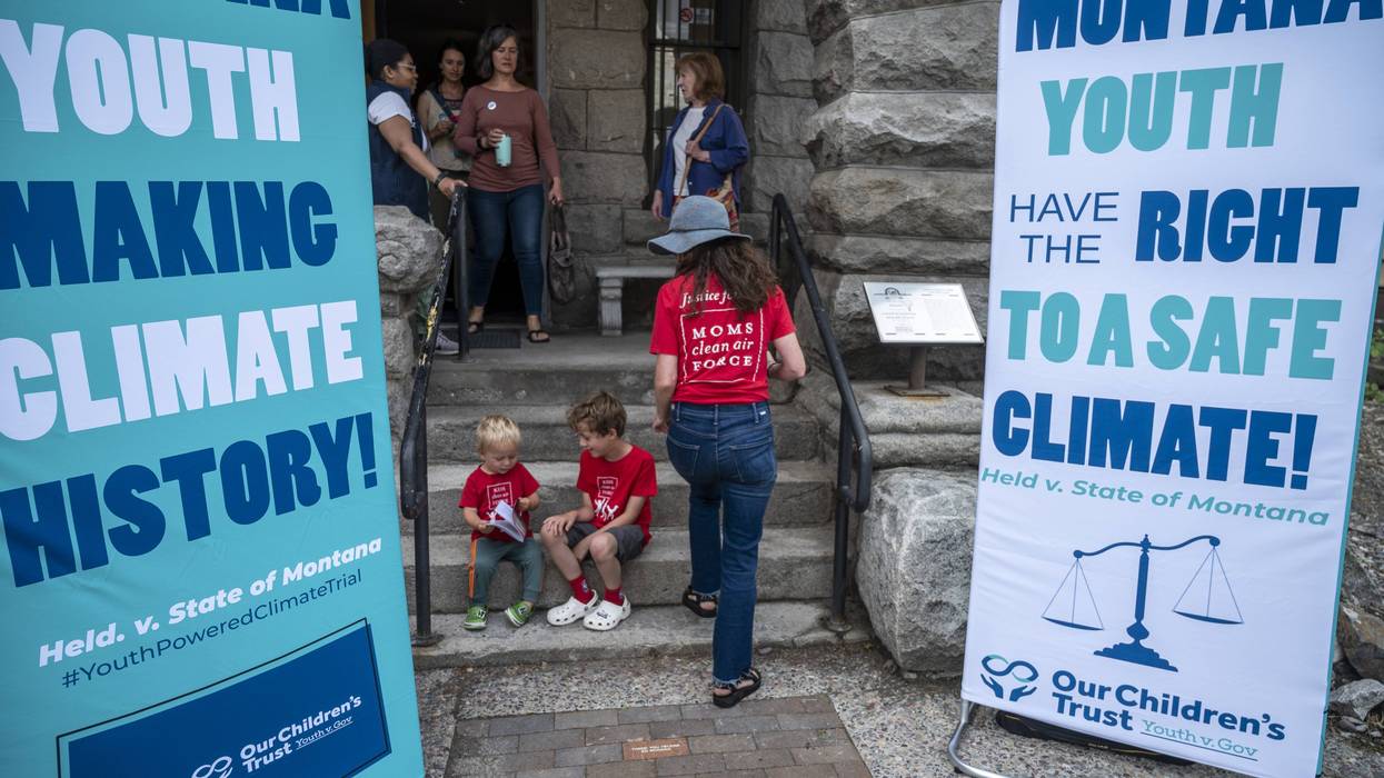 Montana choldren and a mother are seen near signs advocating youth climate justice