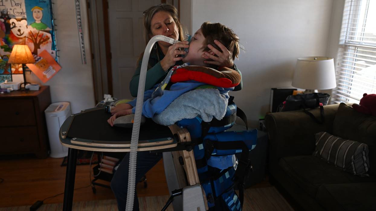 Mother helping her sick child with breathing machine