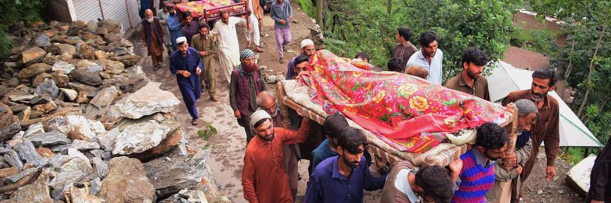 Mourners carry the coffins of people who were killed in flash floods