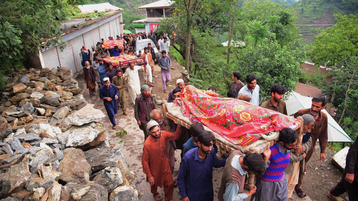 Mourners carry the coffins of people who were killed in flash floods