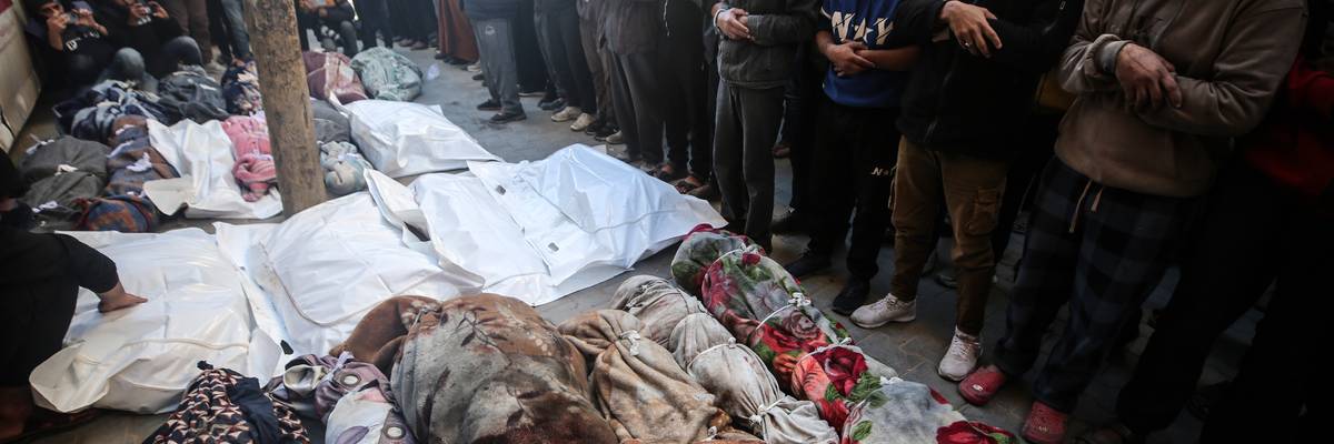 Mourners gather near the bodies of Palestinians killed in an Israeli strike