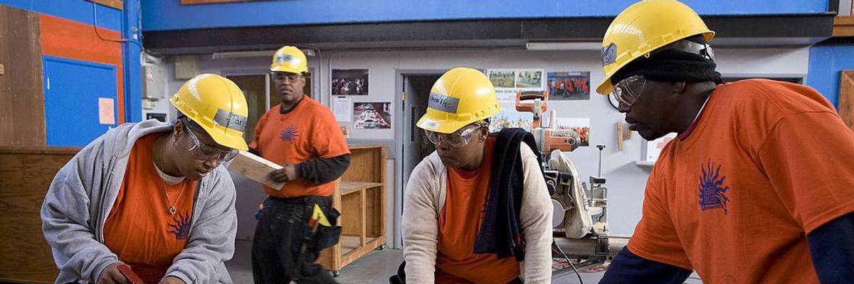 Multiracial workers in hard hats.