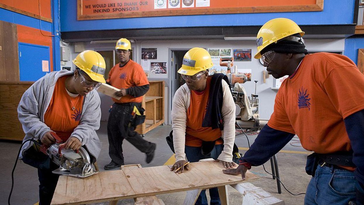 Multiracial workers in hard hats.