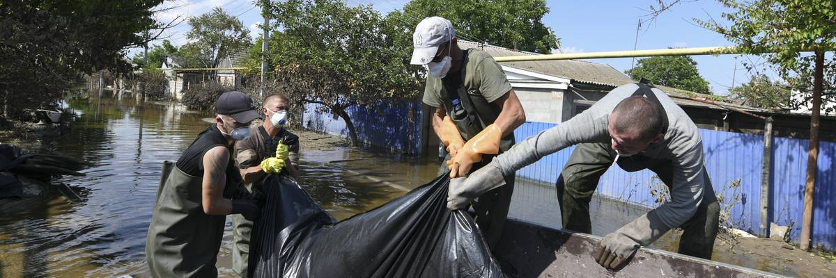 Municipal workers remove dead bodies from flooded houses in Kherson, Ukraine on June 16, 2023, several days after the collapse of the Kakhovka dam.