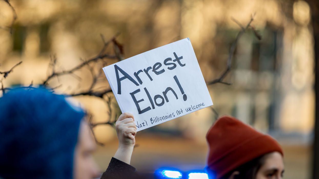 Musk holds up a sign.