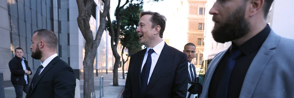Musk surrounded by private security.