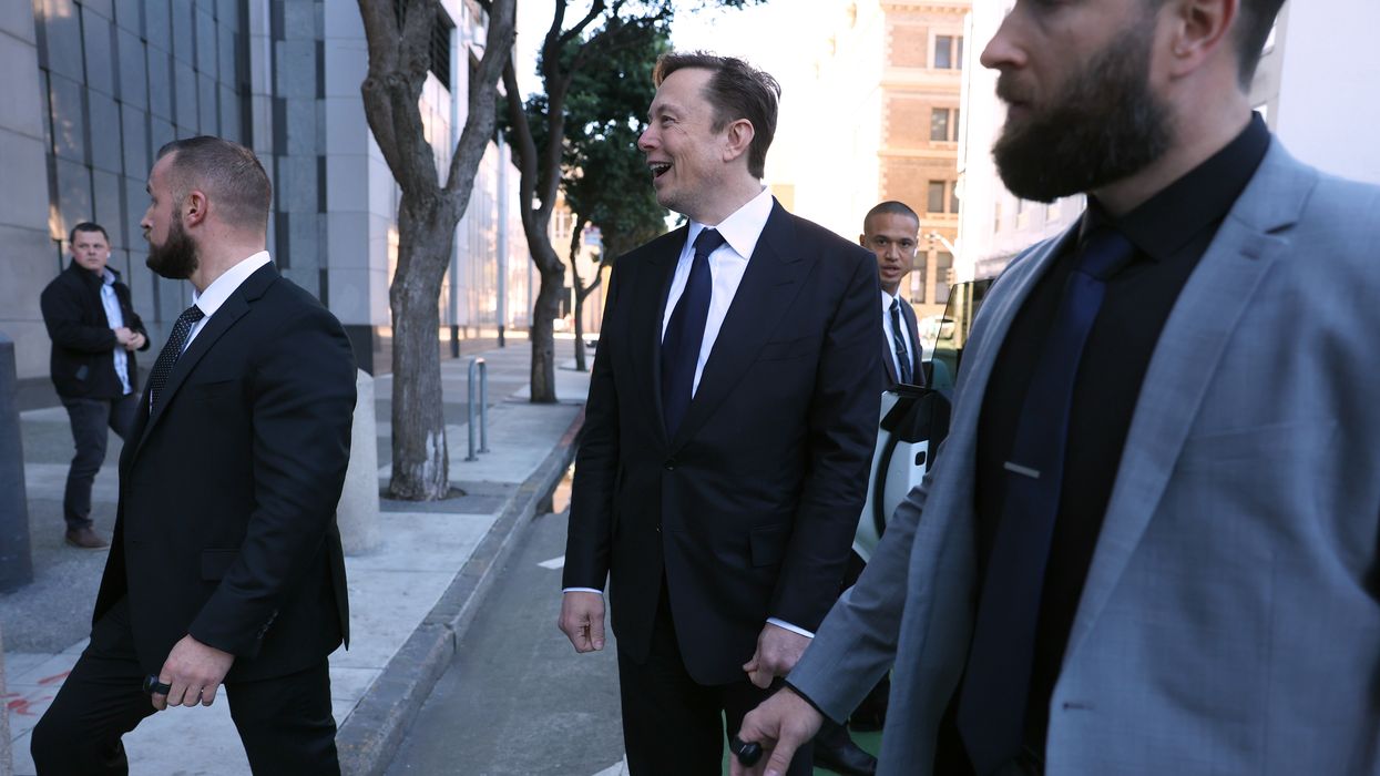 Musk surrounded by private security.