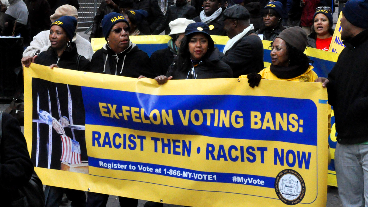 NAACP activists hold a banner reading, "Ex-felon voting bans: racist then, racist now"