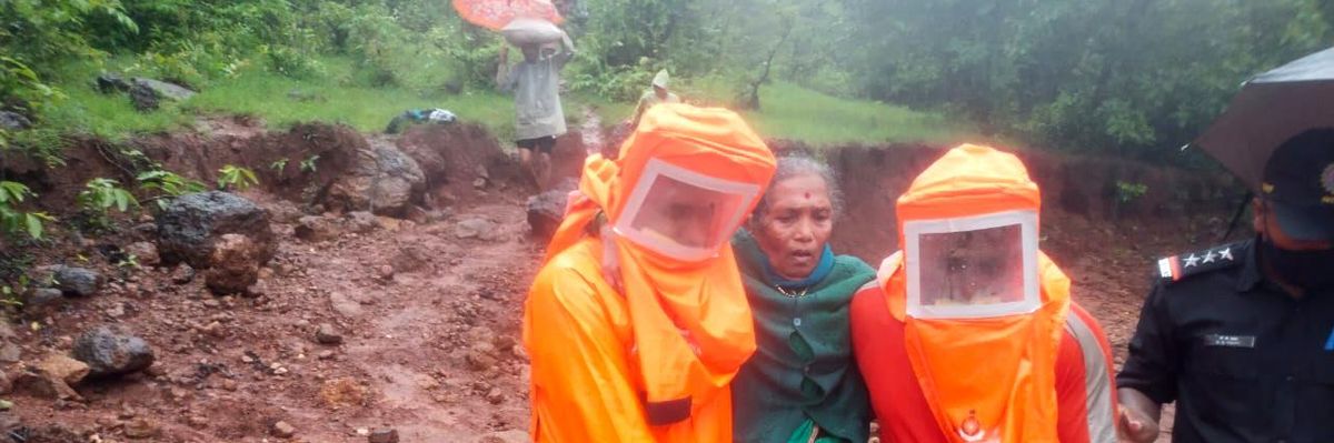 National Disaster Response Force personnel carry a woman in Chikhali village on July 23, 2021, during a rescue operation after heavy monsoon rains in India triggered deadly landslides in the western state of Maharashtra. (Photo: National Disaster Response Force/Handout/Anadolu Agency via Getty Images)